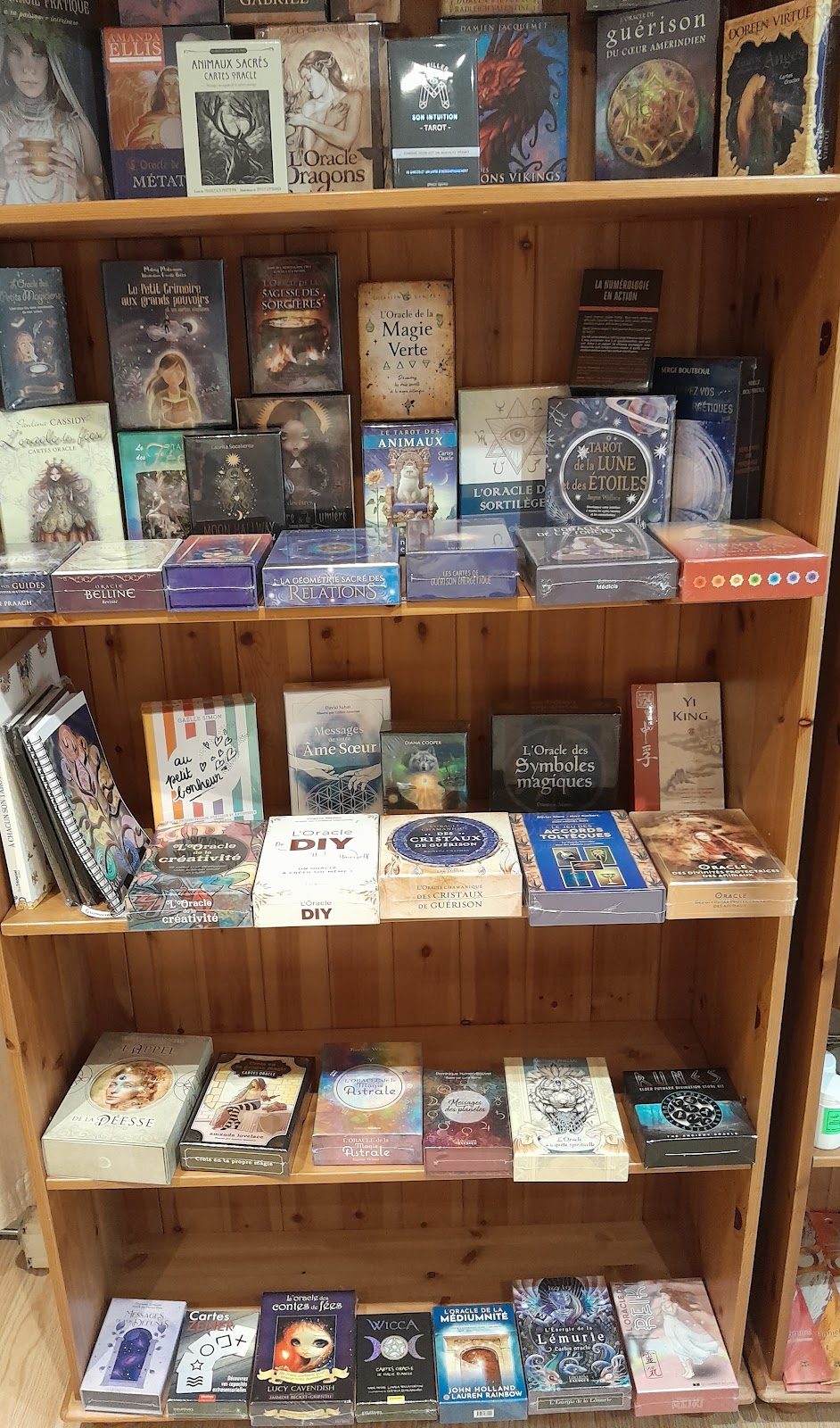 Étagère de livres ésotériques et de coffrets d’oracles